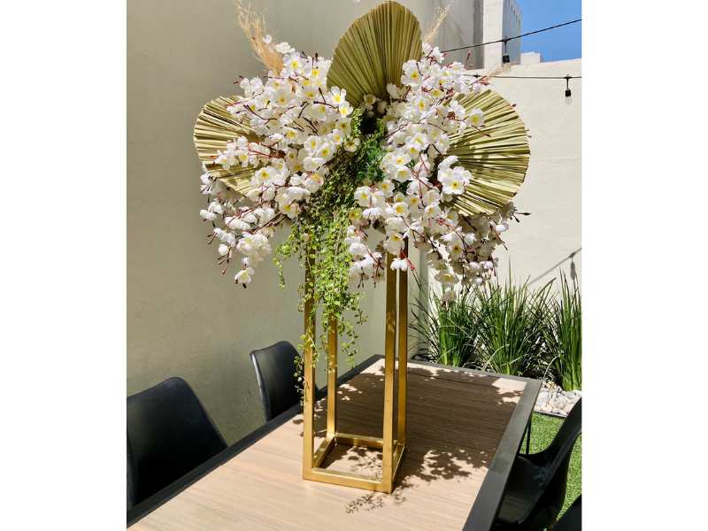 Arreglo Floral en Tonos Blancos con Palmas y Follaje en Base Dorada
